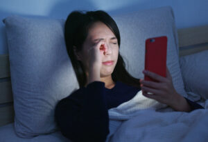 Woman feeling eye pain and lying on bed at night
