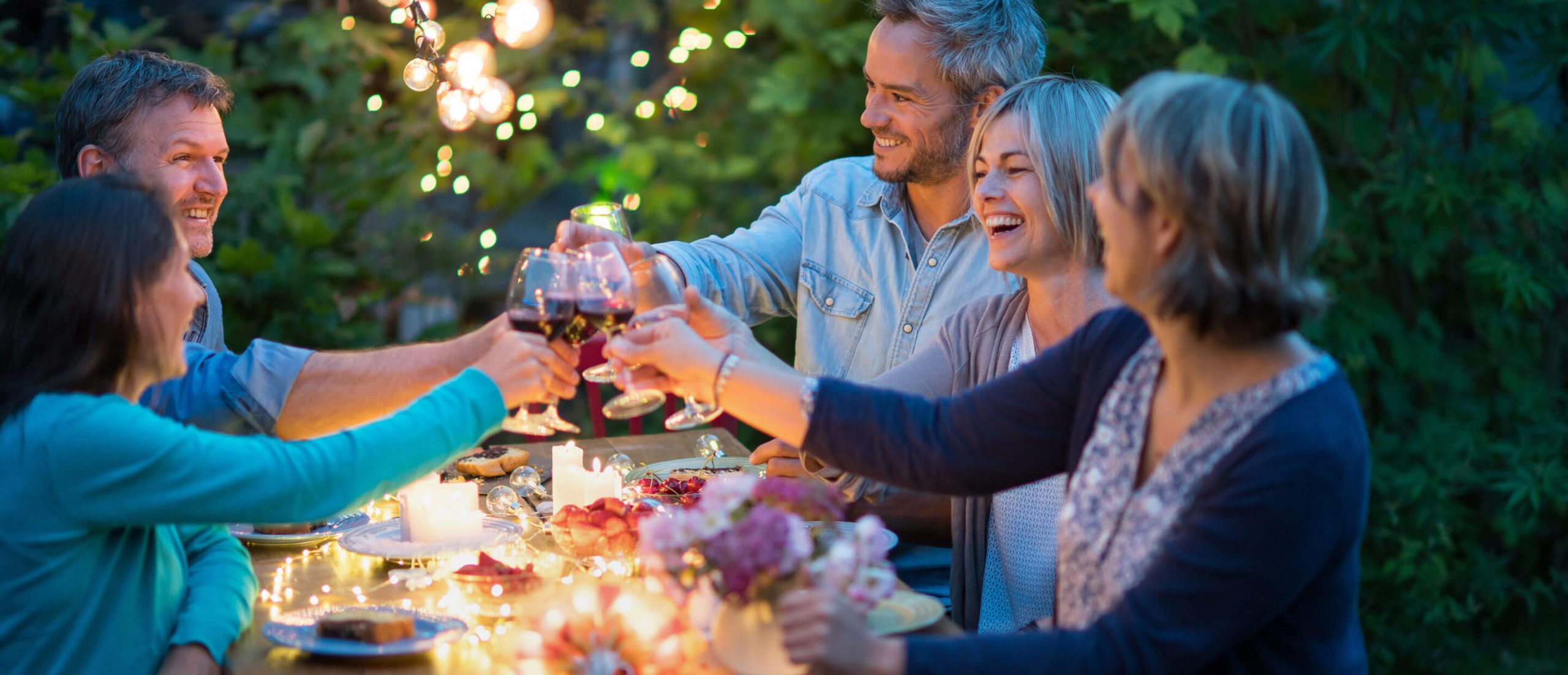 Amis qui mangent autour d'une table à l'extérieur