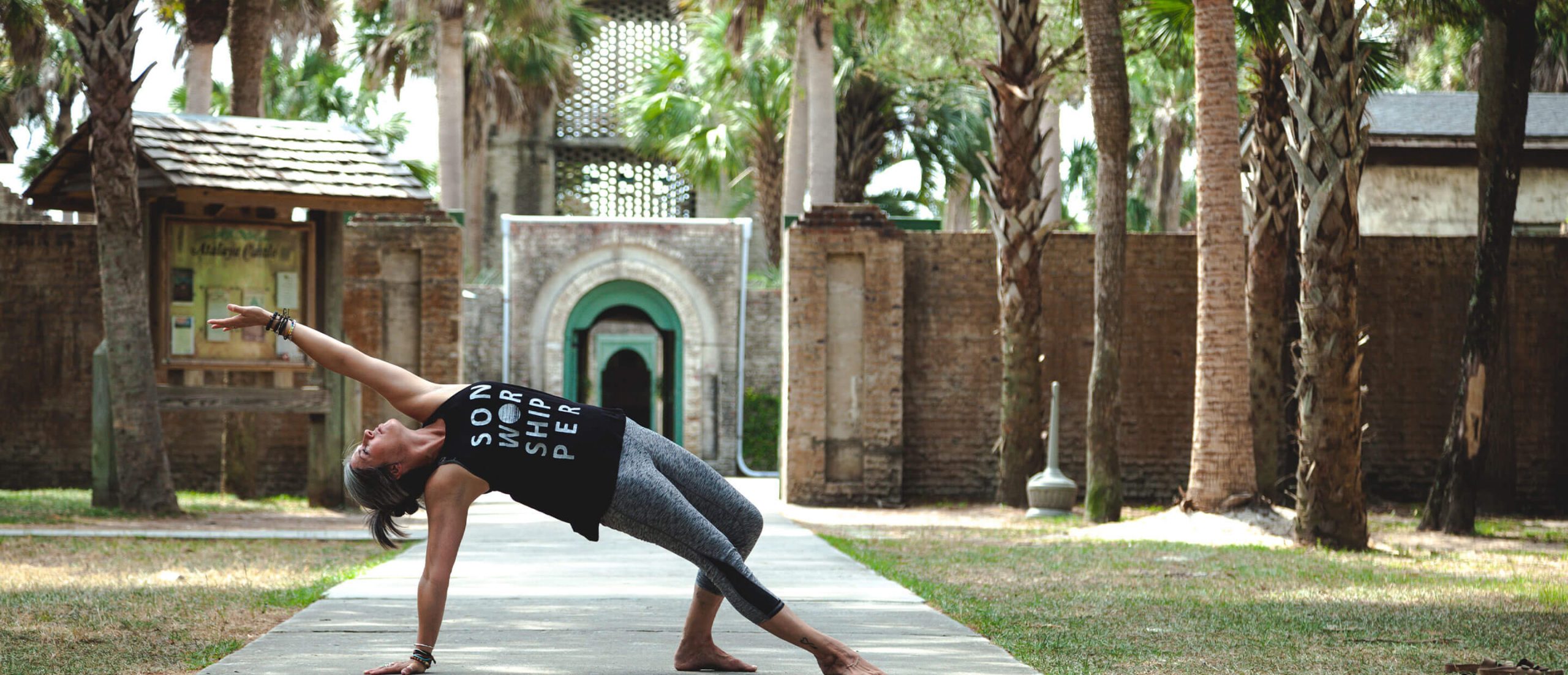 Femme qui fait du yoga devant une porte de temple, article sur la chirurgie de remplacement du cristallin