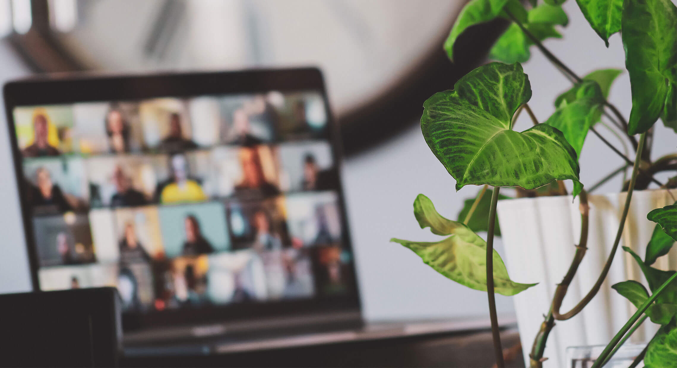 Portable avec plusieurs personnes en réunion à l'écran sur un bureau de travail